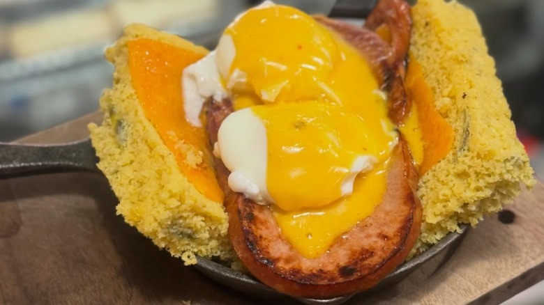 Eggs Benedict dish over ham with cornbread