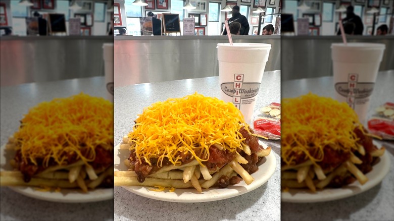 Cheese covered chili dishes with a drink