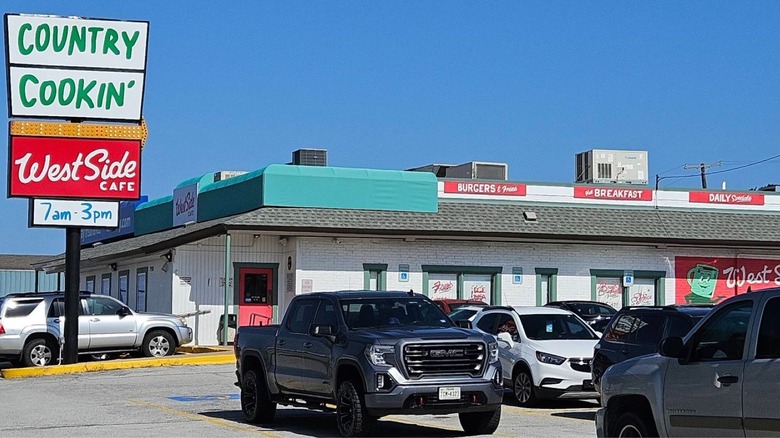A green, white, and red marque advertises country cookin' at West Side Cafe