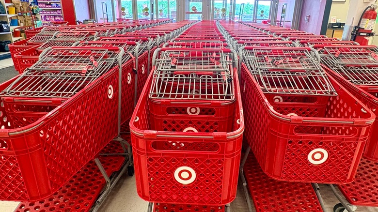 Rows of shopping carts inside an entrance to Target with shelves in the background