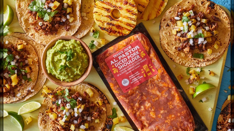 Package of seasoned diced pork shoulder surrounded by tacos and other foods.