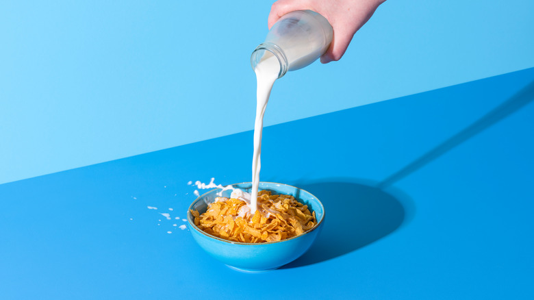 Milk being poured over a cereal bowl