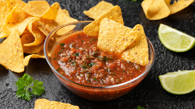 Yellow tortilla chips dipped in restaurant-style red salsa