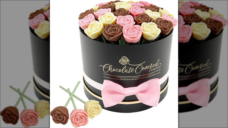 Gift box with assorted colors of chocolate-covered, rose-shaped desserts.