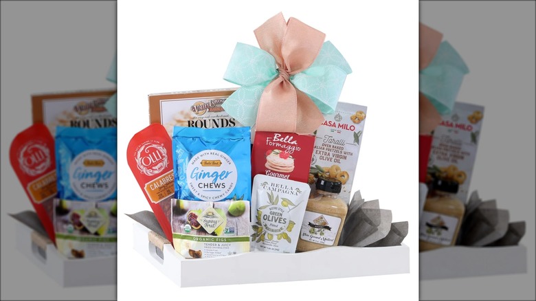 Gift pack with assorted snacks like olives, pretzels, cured meat, and ginger chews.
