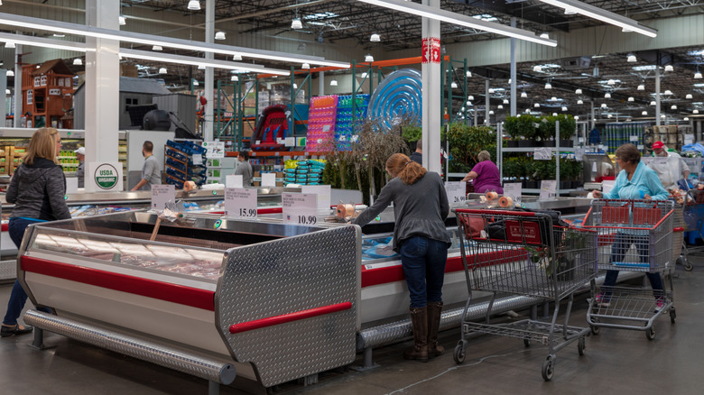 Costco members shopping in the freezer section of the store.