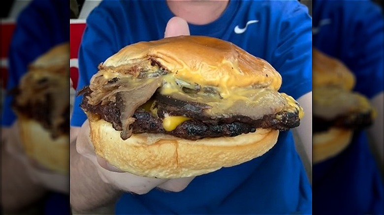 Person holding Hardee's Prime Rib Burger