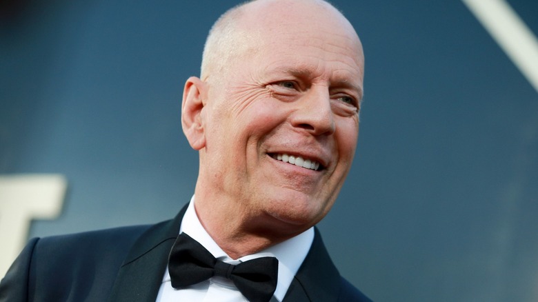 Bruce Willis in a tuxedo, smiling
