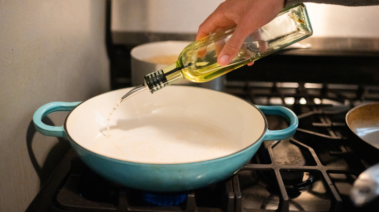 Pouring sunflower oil into a pan.