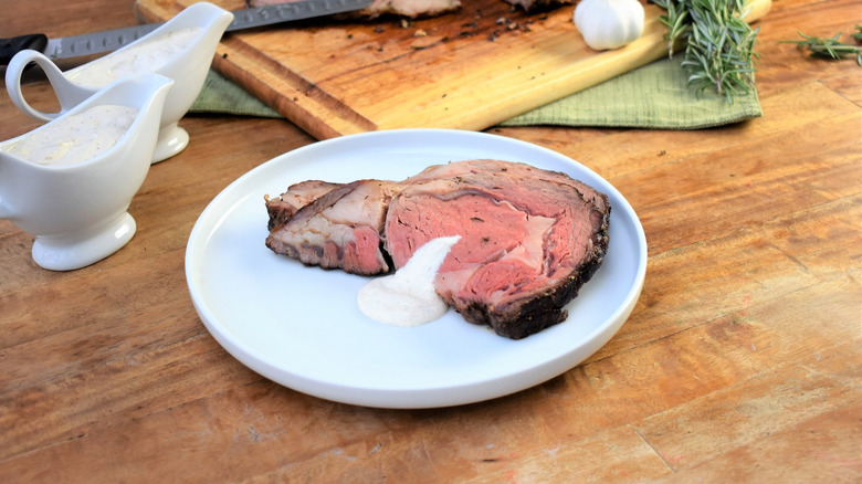 A slice of super juicy prime rib topped with a cream sauce