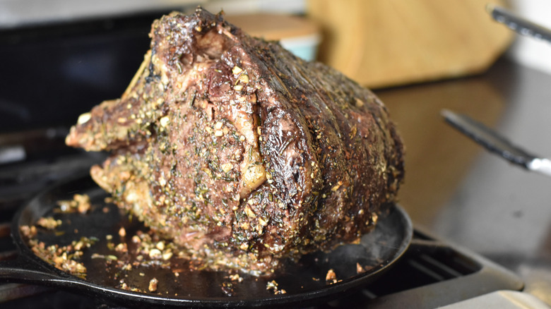 A perfectly cooked prime rib reverse searing in a pan