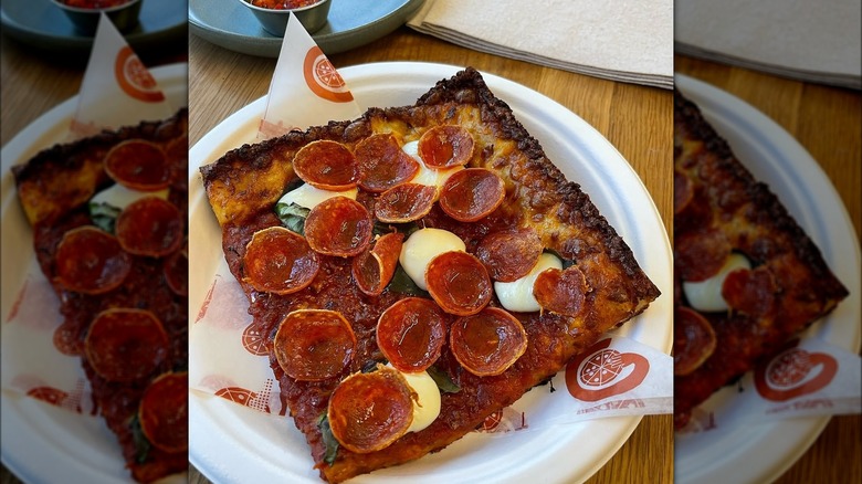A big slice of pepperoni pizza on plate