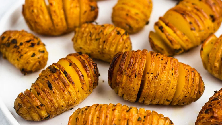 crispy hasselback potatoes on a white plate