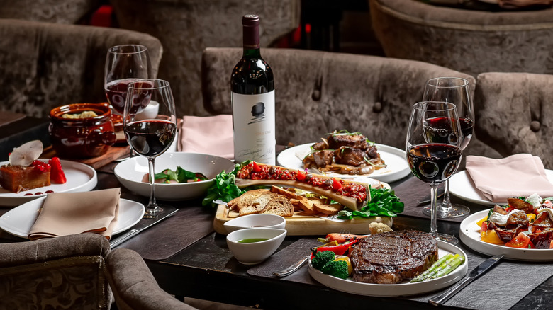 Plated steaks and wine on dining table