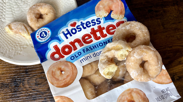 A bag of Hostess Donettes Old Fashioned Mini Donuts with donuts on top of bag and on plate