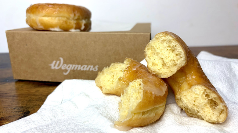 Wegmans glazed donut split in half on a white towel.