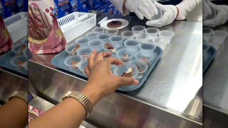 Hand reaching for a sample cup of chocolate at Sam's Club