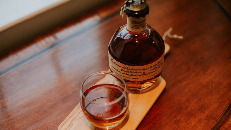 Bottle of Blanton's with glass on wooden table