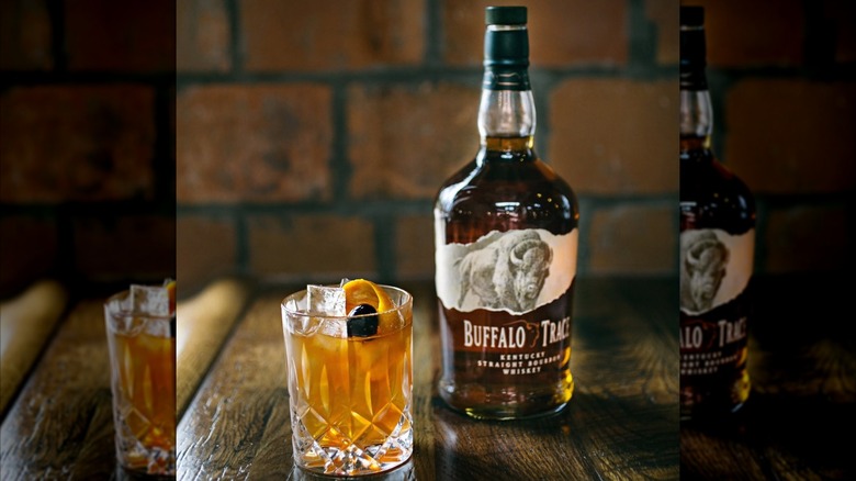 Bottle of Buffalo Trace on wooden table with cocktail in foreground