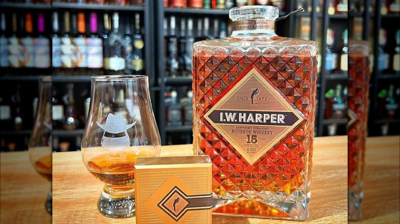 Bottle of I.W. Harper 15-year-old with glass and store shelves blurred in background
