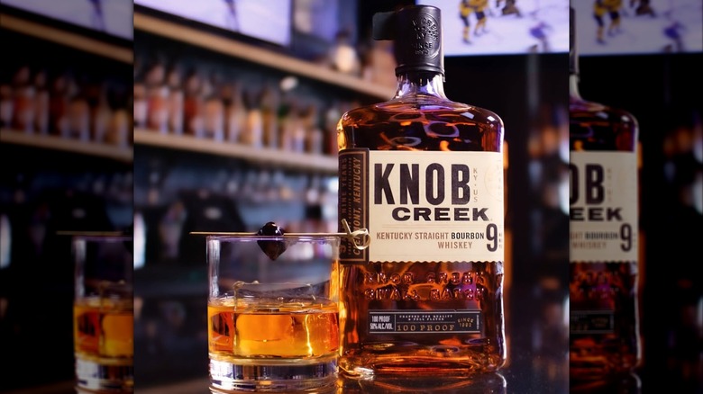 Bottle of Knob Creek 9-year-old on bar with cocktail