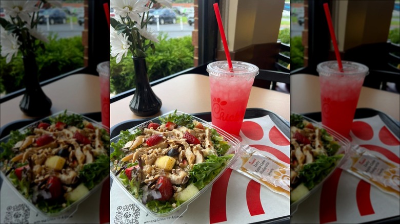 Chick-fil-A Market Salad with beverage and dressing packet on tray inside the restaurant.