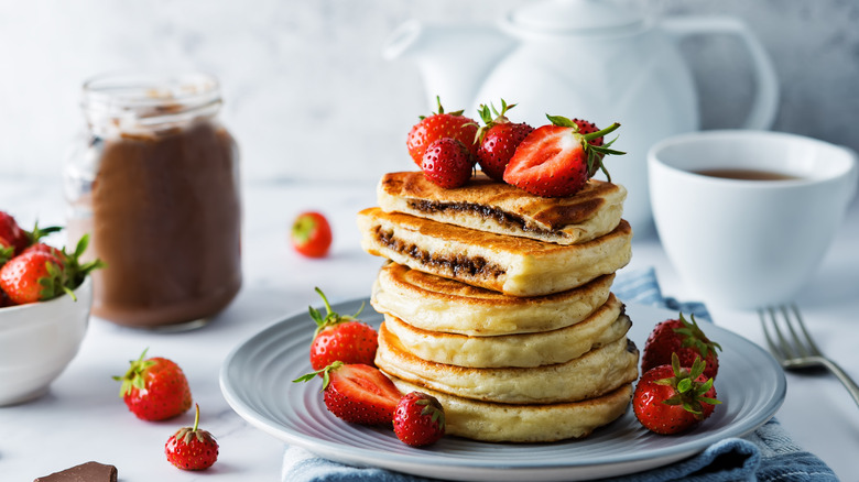 stack of Nutella stuffed pancakes with strawberries