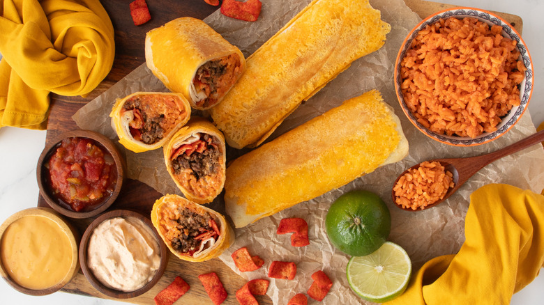 orange-colored burritos on a wooden board