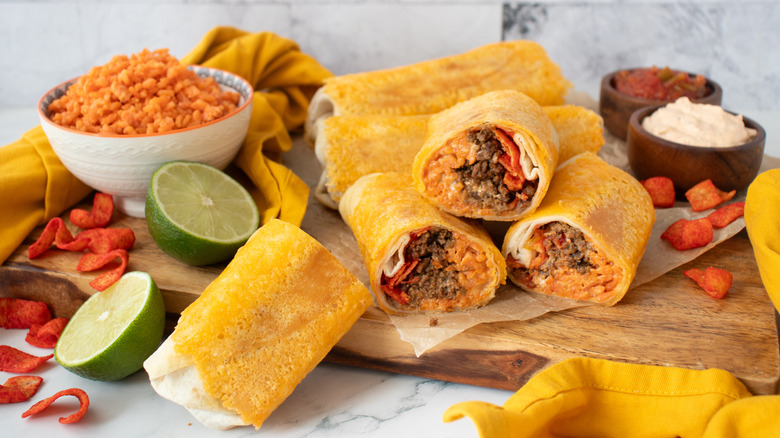 orange-colored burritos on a wooden board