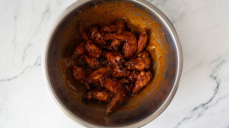 Saucy chicken wings in bowl