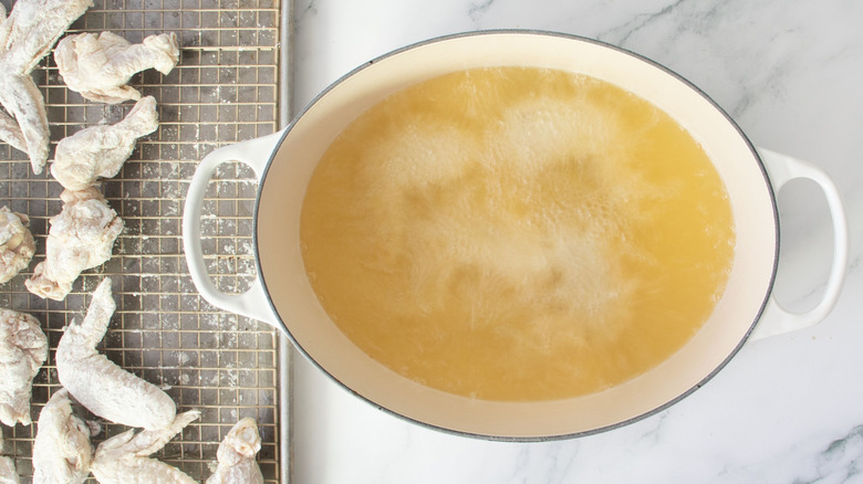 Flour-coated wings next to pot of bubbling oil