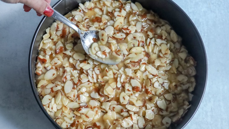 Spooning buttery almond mixture into springform pan