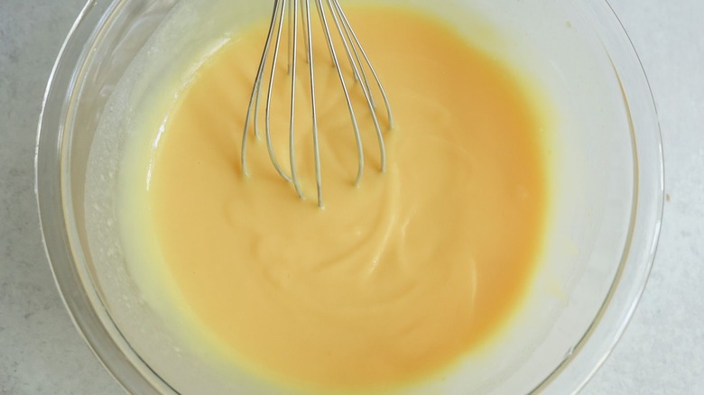 Vanilla pudding in bowl with whisk