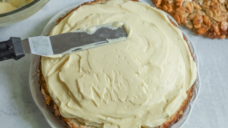 Offset spatula spreading pudding over cake layer