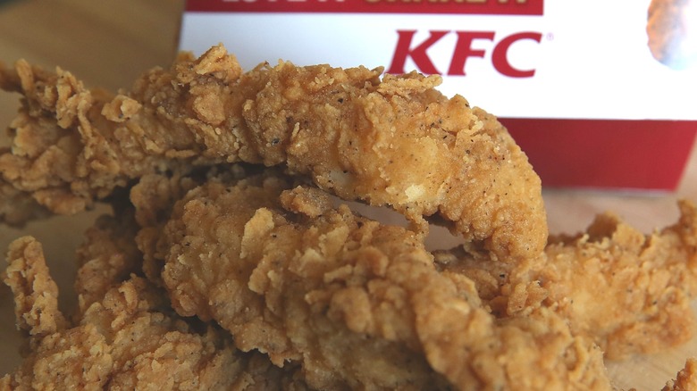 Close up of KFC chicken tenders in front of a KFC paper box