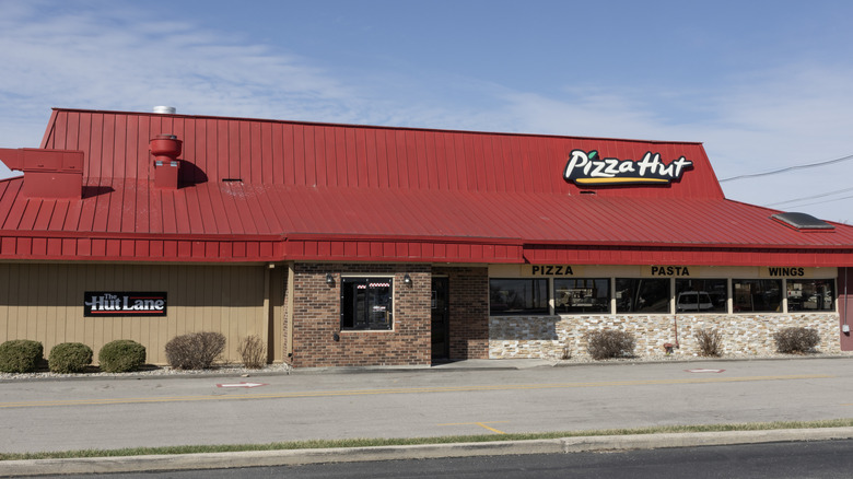 Exterior of a classic Pizza Hut building with its signature red roof