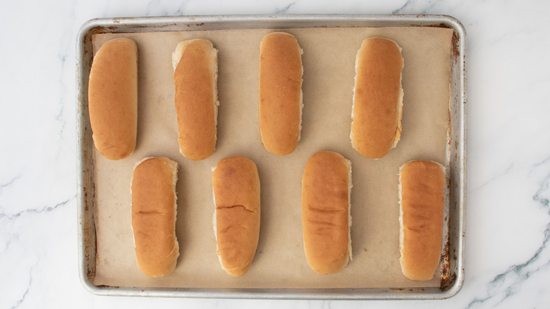 Hot dog buns on baking sheet