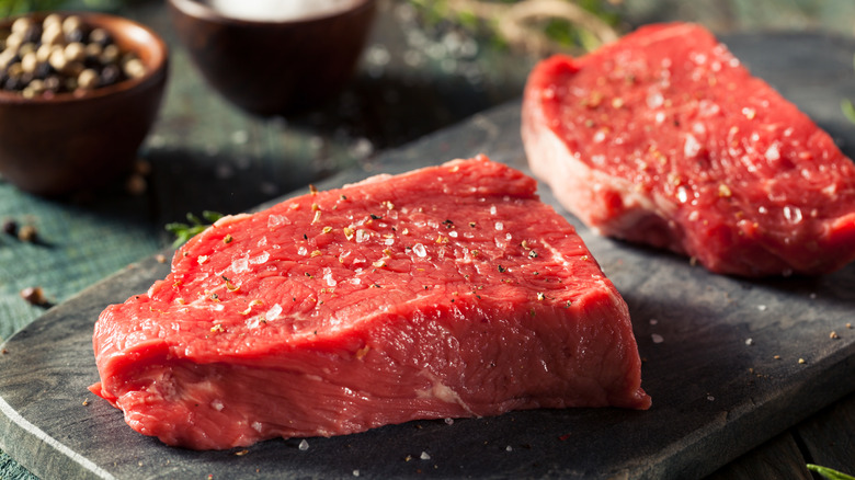 seasoned steaks resting before cooking