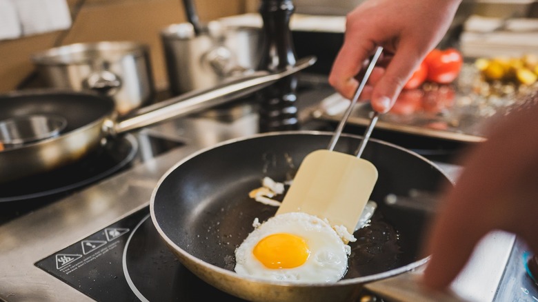 person using spatula to flip eggs