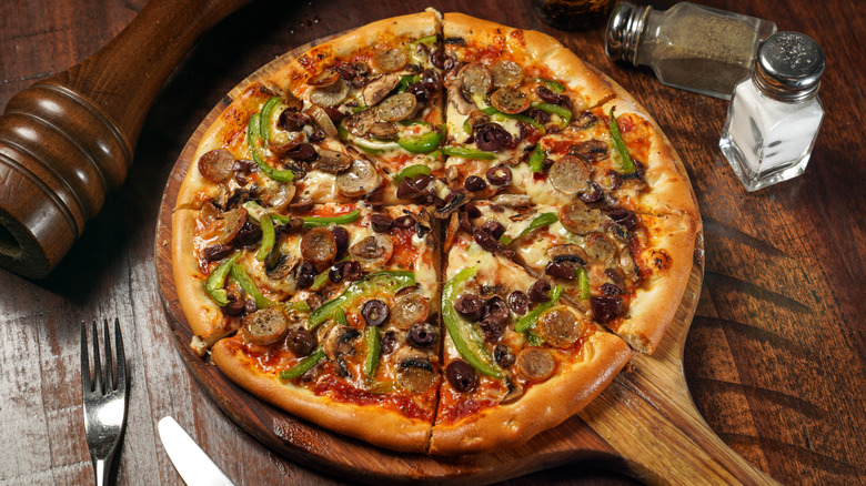 combo pizza on a wood peel