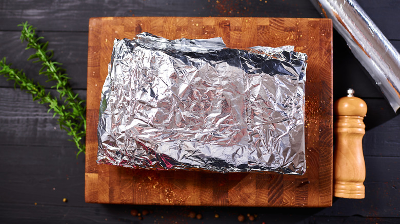Roast covered in foil on cutting board waiting to be cooked