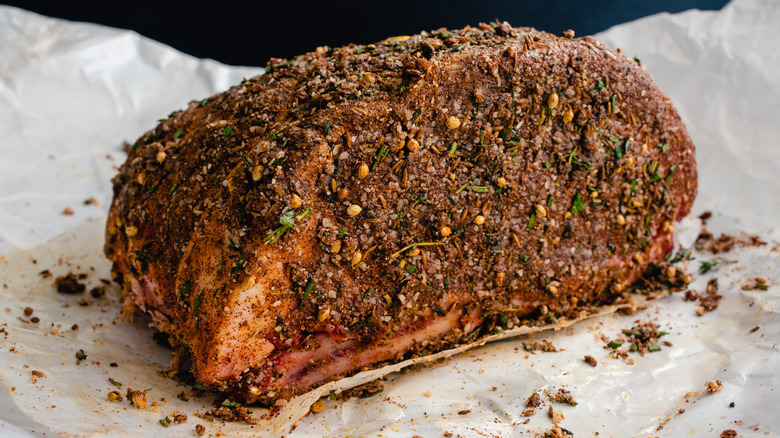 Heavily seasoned uncooked prime rib resting on parchment