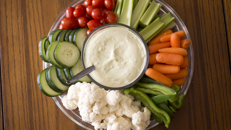 Vegetable plate assortment with bowl of ranch dressing in the middle