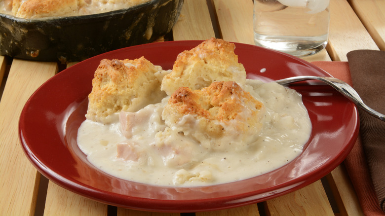 Plate of white gravy with biscuits on top