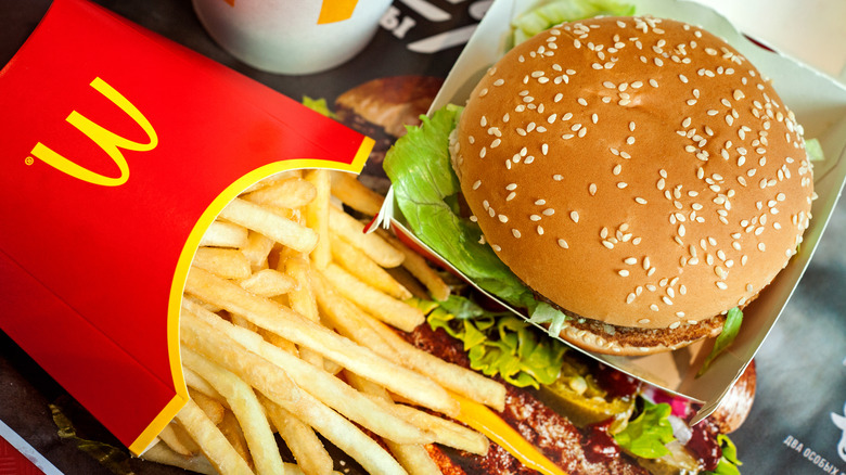 McDonald's hamburger sandwich next to a side of fries