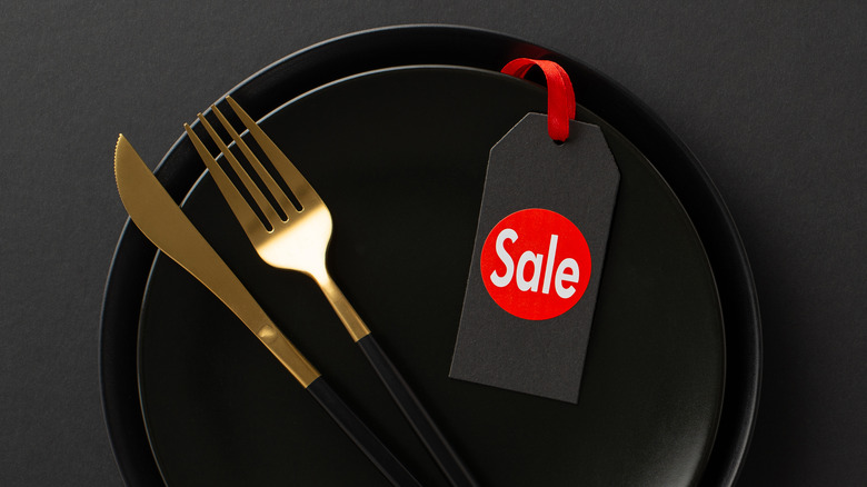 Black Friday promo with sales tag, black plate, fork, and knife
