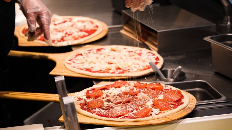 pizzas being prepared for baking