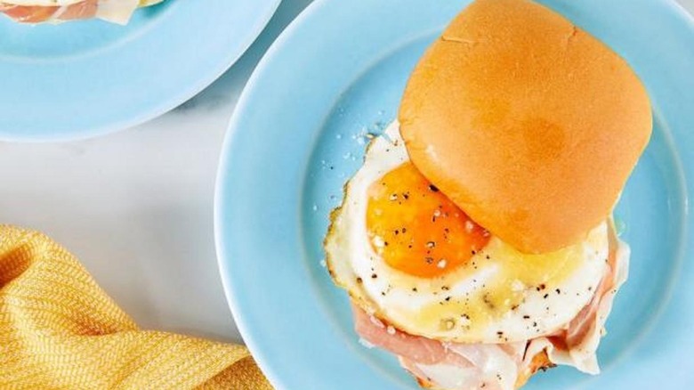Egg sandwich on blue plate with yellow napkin