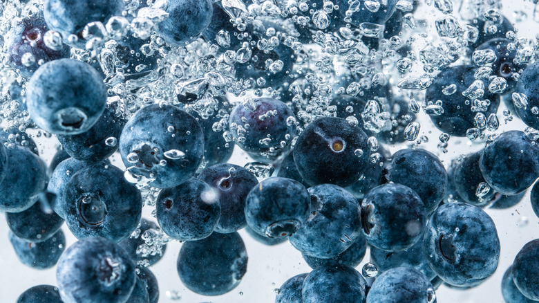Blueberries falling into water