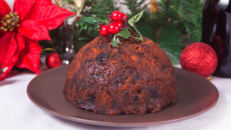 Traditional molded Christmas pudding decorated with red berries